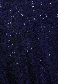 Tengerészkék flitteres anyag tükröződő kerek flitterekkel, sűrű textúrával, egyenetlen elhelyezkedéssel, amely csillogó hatást kelt sötét háttér előtt.