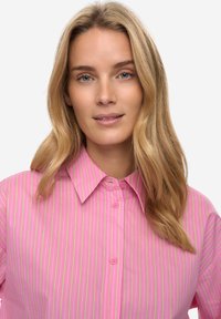 Roze overhemd met kraag en verticale strepen in geel en wit. Heeft een knoopsluiting en een gladde textuur.