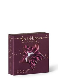 Lila Box mit sternförmigem Fenster, das ein passendes lilanes Seidenscrunchie zeigt, beschriftet mit "lesilque Pure Moments Luxus-Seidenscrunchie."
