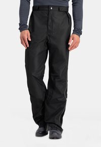 Zwarte waterdichte buitenbroek met een rechte snit, elastische tailleband, ritszakken en versterkte bescherming bij de naden. Glad textiel.