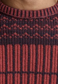 Gestrickter Pullover mit Rippenstruktur. Verfügt über abwechselnde Streifen in Dunkelblau und Rostrot, mit Rundhalsausschnitt und markanten Mustern.