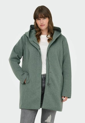 Grön ullblandad kåpa med huva, tryckknappar, sidofickor och en avslappnad passform. Texturerad tyg och knälång design.