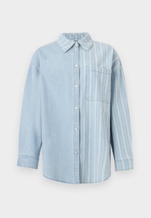 Chemise en denim bleu clair à manches longues, boutonnée sur le devant, design fendu : partie gauche unie et partie droite à rayures verticales blanches avec une poche poitrine.