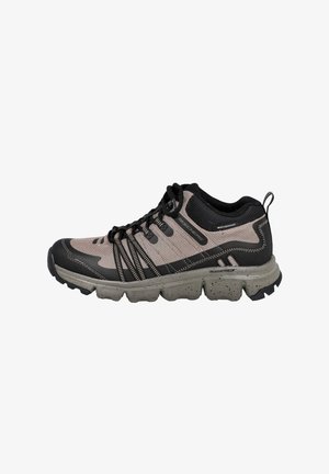 Zapatilla deportiva impermeable Skechers color marrón claro y negro con suela gruesa y resistente y cordones negros, mostrada desde el lado exterior.