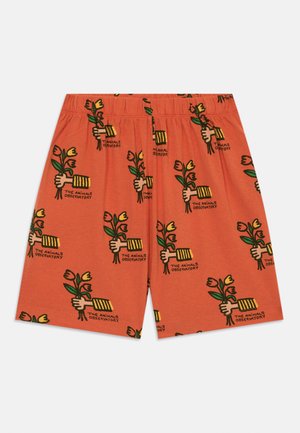 Shorts de algodón naranja con un patrón repetitivo de manos sosteniendo flores y texto, con un corte relajado y cinturilla elástica.