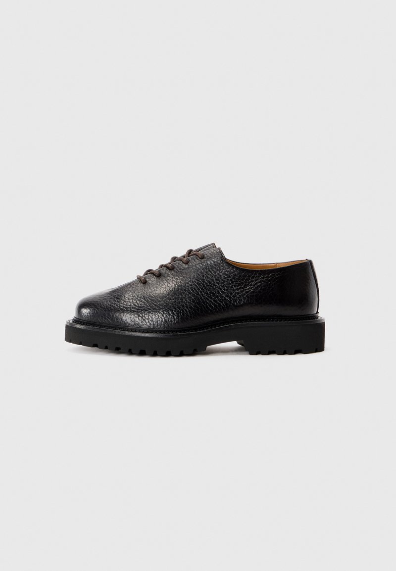 Black leather lace-up shoes with a textured finish and a rugged rubber sole. Features rounded toe and low-profile design.