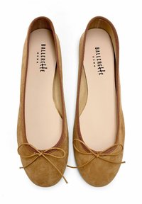 Ballerines en daim marron avec un bout arrondi, doublure douce et un accent délicat en nœud à l'avant. Logo imprimé sur la semelle intérieure.