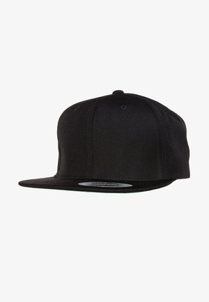 Black snapback cap with a flat brim, textured fabric, and contrasting green under the brim. Features multiple ventilation eyelets.