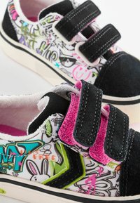 Sorte og hvide sneakers med tegneserieprint, pink og grønne detaljer, velcroremme og tekstureret stof. Gummisål, afslappet design.