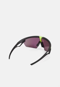 Sonnenbrille mit einem schwarzen Rahmen und lila Gläsern. Zu den Merkmalen gehören ein aerodynamisches Design, verstellbare Nasenpolster und leuchtend grüne Akzente.