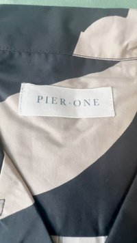 Tessuto nero e beige con motivo, dalla texture liscia, che presenta un'etichetta bianca con la scritta "PIER ONE" in caratteri scuri.