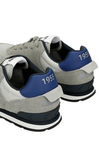 Sneaker in suede grigio e rete con accenti blu, caratterizzati da una intersuola bianca e un suola in gomma nera. "1955" stampato sul tallone.