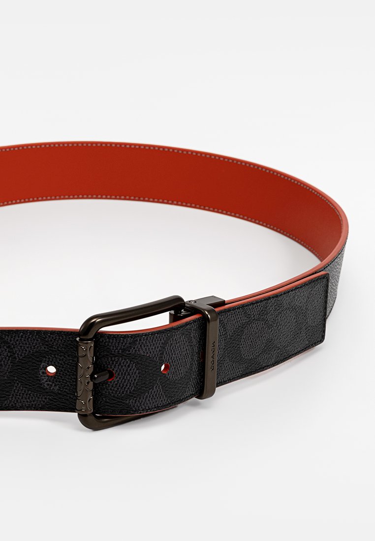 Schwarzer, gemusterter Ledergürtel mit orangefarbenem Innenfutter, ausgestattet mit einer rechteckigen metallischen Schnalle und gesteppten Details entlang der Kante.
