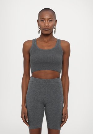 Sivý rebrovaný crop top s okrúhlym výstrihom a zodpovedajúcimi priliehavými cyklistickými šortkami. Vyrobené z mäkkého, elastického materiálu, ktorý ponúka bezšvový vzhľad.