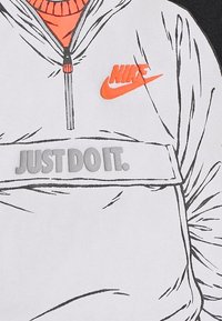 Vit zip-up jacka med huva, med orange accentuer och Nike-logotyp. "JUST DO IT." text i grått över bröstet. Slät textur.