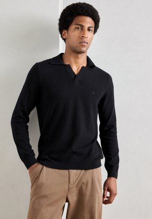 Zwarte lange mouwen polo trui met een V-hals en geribbelde manchetten, gemaakt van zacht materiaal, met een subtiele logo op de linkerkant van de borst.