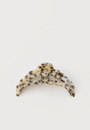 Pinza para el cabello de plástico mármol en beige y negro con dientes curvos y un cierre de resorte metálico.