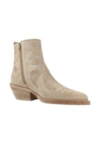 Botas de tobillo de ante beige con puntera afilada, perforaciones decorativas y cremallera lateral. Tacón de madera apilada.