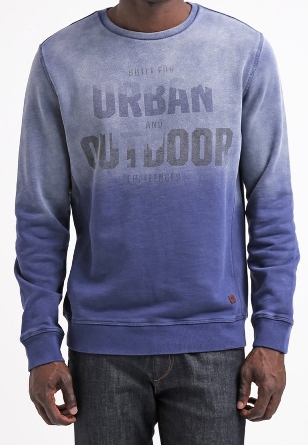 Homme portant un sweat-shirt à manches longues bleu dégradé avec le texte « Urban and Outdoor » imprimé sur le devant.