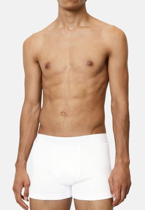 Weiße Baumwoll-Boxershorts mit geripptem Textur und einem weichen, elastischen Bund mit dem Markennamen. Von einem Modell getragen, vor einem neutralen Hintergrund.