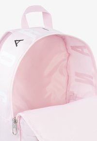 Rosa Rucksack mit glattem Außenmaterial, ausgestattet mit einer großen Reißverschlussöffnung und weicher Innenseite. Auffälliges Design mit weißem, aufgedrucktem Text.
