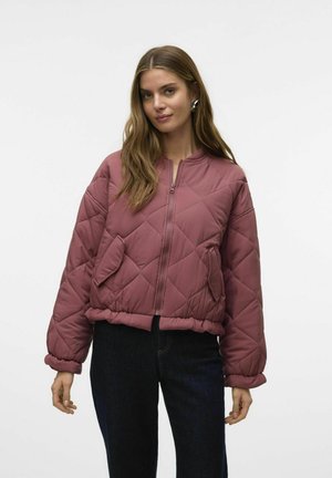 Veste bomber matelassée bordeaux avec une fermeture éclaire à l'avant, des poignets côtelés et deux poches latérales. Matière douce et rembourrée avec une coupe décontractée.