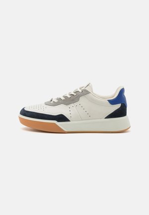 Sneaker aus weißem Leder mit grauen Wildlederakzenten, ausgestattet mit einer blauen Ferse, einem durchbrochenen Design und einer Gummisohle.