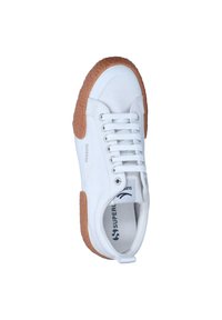 Sneaker bianco con suola in gomma marrone texturizzata, design con lacci e parte superiore in tela morbida. Presenta il marchio del brand sul lato.