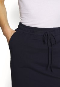 Shorts de jogging légers bleu marine en tissu doux, dotés d'une taille élastique, d'un cordon de serrage et de poches latérales.