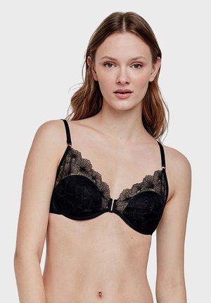 Soutien-gorge en dentelle noire avec un design floral, soutien-gorge à armatures, bretelles réglables et fermeture à crochets à l'avant. Tissu doux avec des détails texturés.
