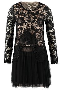 Haut noir à manches longues en dentelle florale avec des détails transparents sur une doublure couleur nude, associé à une jupe en tulle noire à volants.