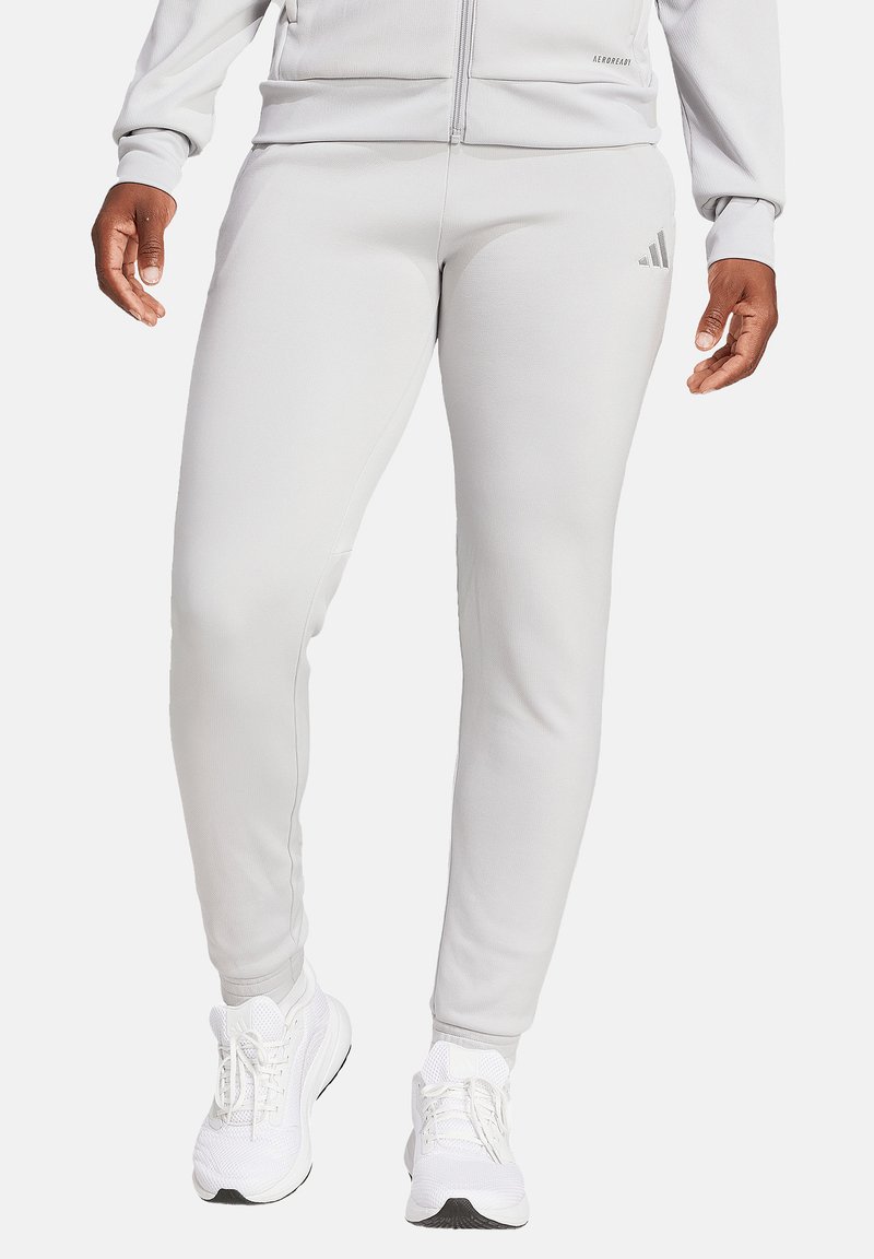 Light gray athletic pants made from smooth fabric, featuring a slim fit. Includes subtle three-stripe logo detail on the left leg.
