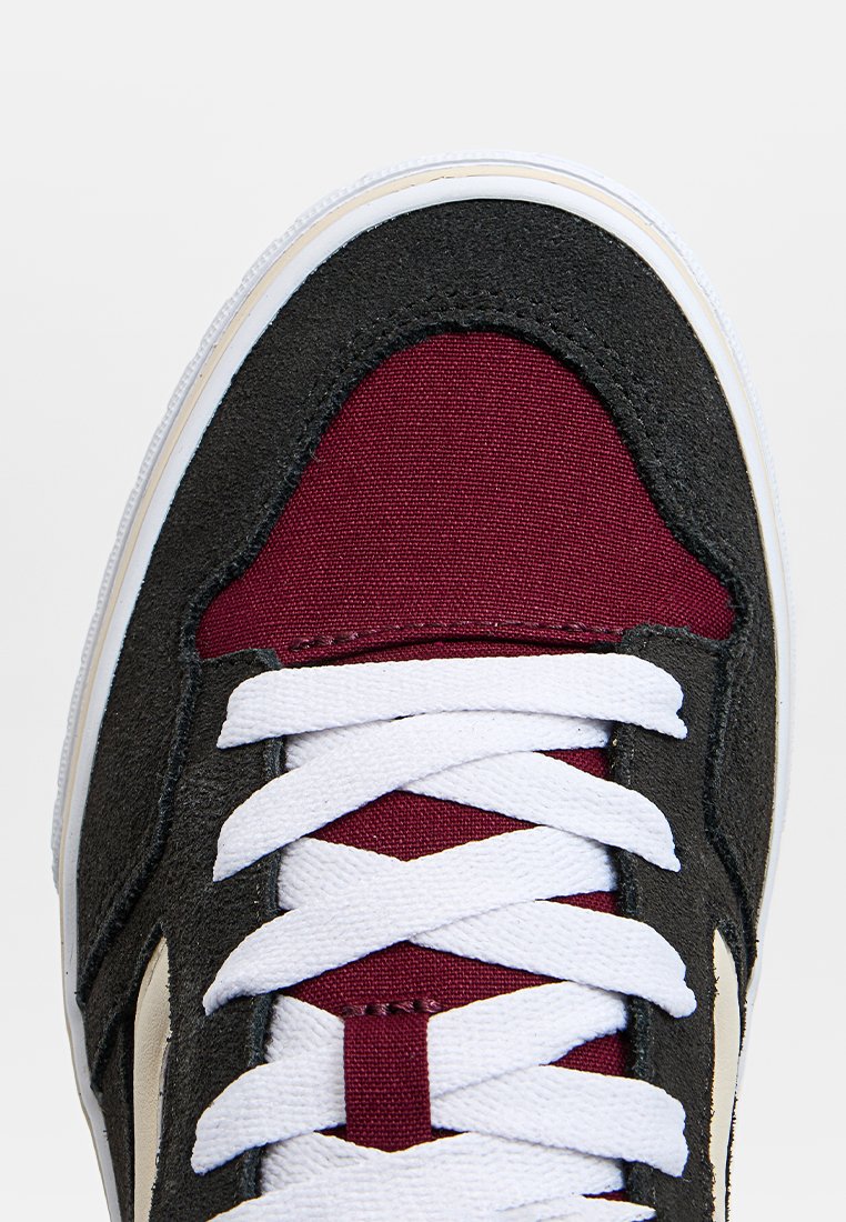 Zapatilla negra y burdeos con una parte superior de tejido y ante, cordones blancos y suela de goma blanca. Cuenta con una lengüeta acolchada y acentos texturizados.