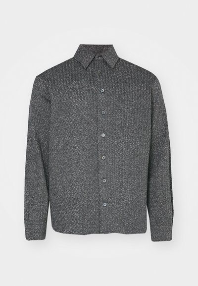 Camisa de manga larga abotonada en negro y gris con un patrón de diamantes texturizado, que cuenta con un cuello de punta y cinco botones en la parte delantera.