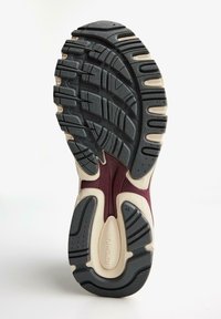 Shoe sole featuring a black rubber tread, textured pattern, and cream accents. Notable details include grooves and a maroon section. Size 42.