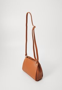 Bolso bandolera de cuero marrón con una superficie texturizada, forma redondeada, acentos en hardware dorado y cierre con cremallera en la parte superior.