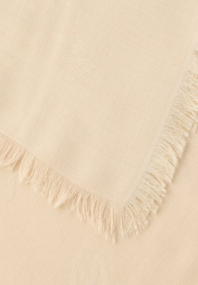 Μπεζ υφαντό ύφασμα με διακριτικό τονικό μοτίβο και φράντζες στις άκρες, που δείχνει την υφή και λεπτομέρειες από ραφή.