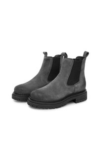 Botas Chelsea de ante gris con paneles laterales elásticos negros, lengüetas para tirar y suelas de goma negra gruesa. Detalles de costura alrededor de la suela.