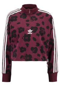 Sudadera burdeos con cremallera y patrón floral negro. Presenta logo blanco de Adidas y tres franjas verticales blancas en cada manga. Diseño recortado.