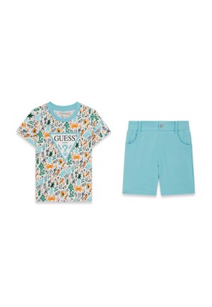T-shirt bianca a maniche corte con motivi del logo GUESS colorati e pantaloncini azzurri con tasche frontali e chiusura con bottone.