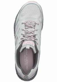 Zapatilla deportiva de color gris claro con detalles en rosa, parte superior de malla, cordones texturizados y plantilla acolchada etiquetada como "Memory Foam". Suela exterior de goma negra.