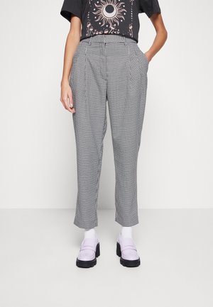 Pantalons taille haute à motif pied-de-poule noir et blanc avec poches latérales, présentant une coupe ajustée et des jambes droites.