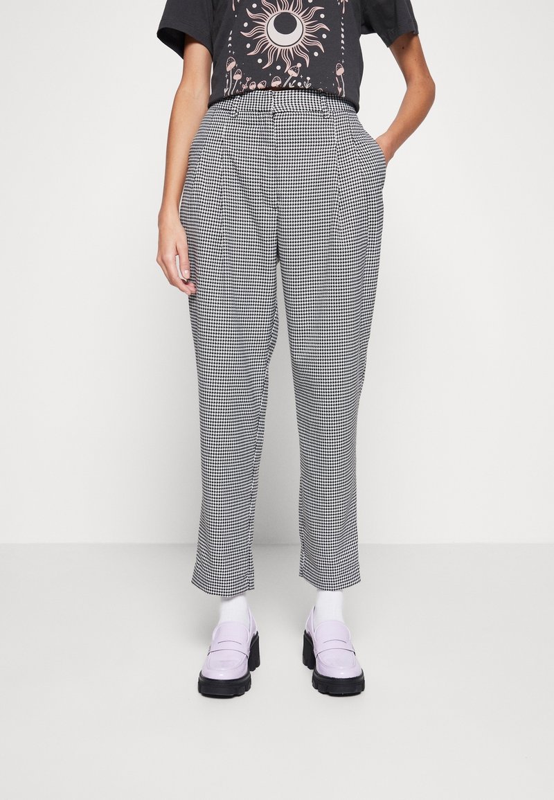High-waisted, black and white houndstooth patterned trousers with side pockets, featuring a tailored fit and straight legs.