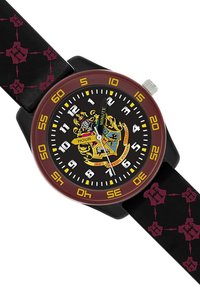 Montre ronde avec un bracelet en cuir noir, dotée d'une lunette bordeaux, d'un cadran noir, de marqueurs d'heure blancs et jaunes, et d'un motif de blason détaillé.
