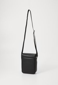 Sort crossbody taske, lavet af tekstureret syntetisk materiale, rektangulær form, har en lang justerbar rem og en lynlåsslukning.