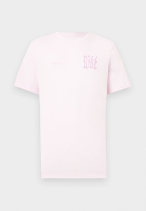 Maglietta a maniche corte di colore rosa chiaro con scollo rotondo e scritta gotica "WKE" sbiadita sul petto in alto a sinistra.