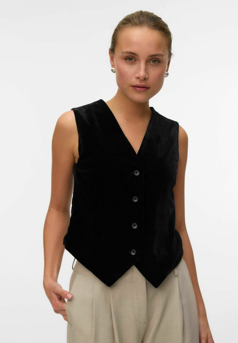 Gilet senza maniche in velluto nero con scollatura a V, dotato di sei bottoni frontali e una forma aderente, progettato per un aspetto sartoriale.