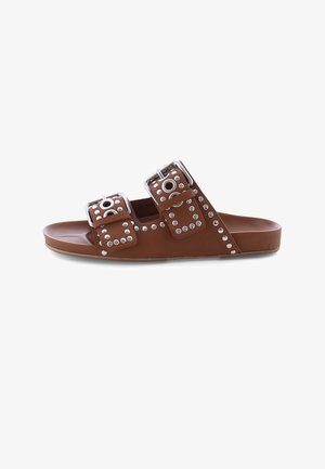 Brown slide sandal with two adjustable buckled straps featuring circular metal studs and eyelets.