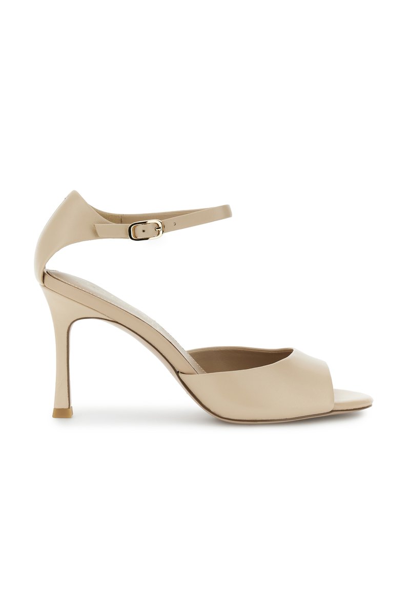 Beige high-heeled sandals with an open toe, featuring a sleek strappy design, smooth leather material, and a slender stiletto heel.