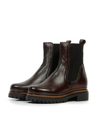 Paire de bottines Chelsea en cuir brun foncé avec des panneaux latéraux élastiques noirs, des semelles épaisses à crampons et des languettes à l'arrière.
